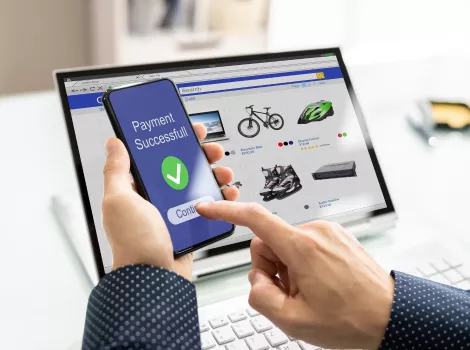 Person verpackt ein Produkt aus einem Onlineshop in einem stilvollen Karton.